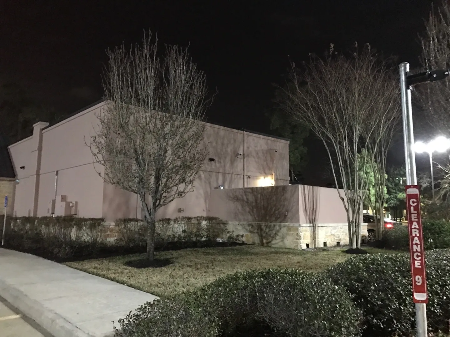 A building with trees and bushes in front of it