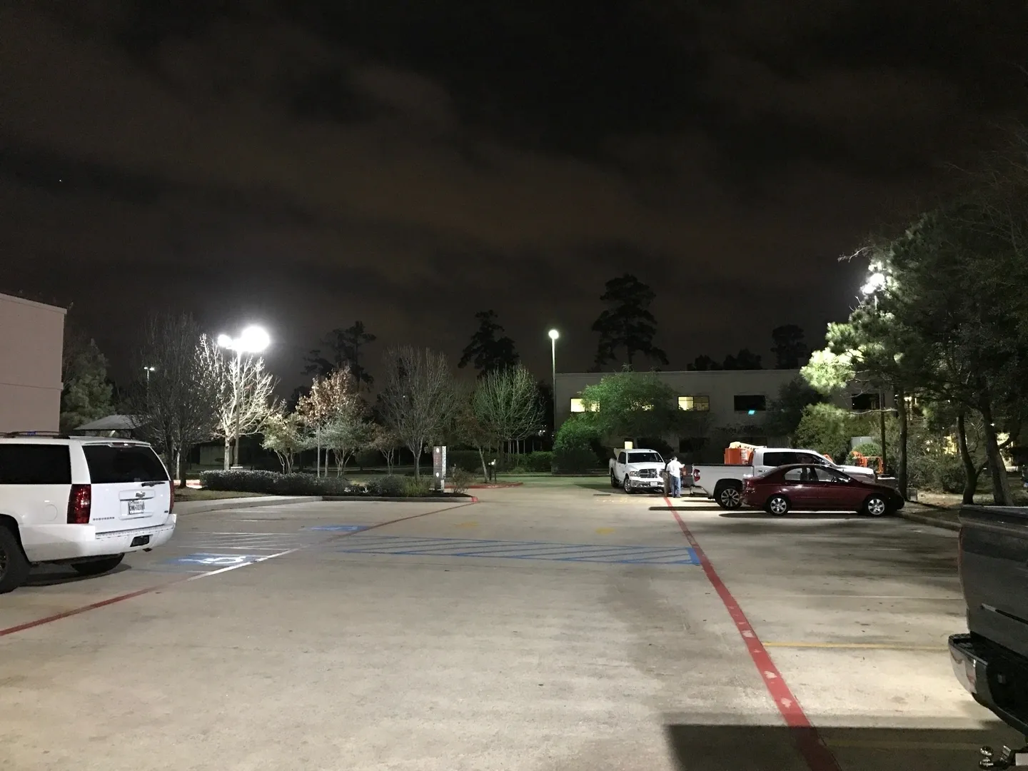 A parking lot with cars parked in it at night.