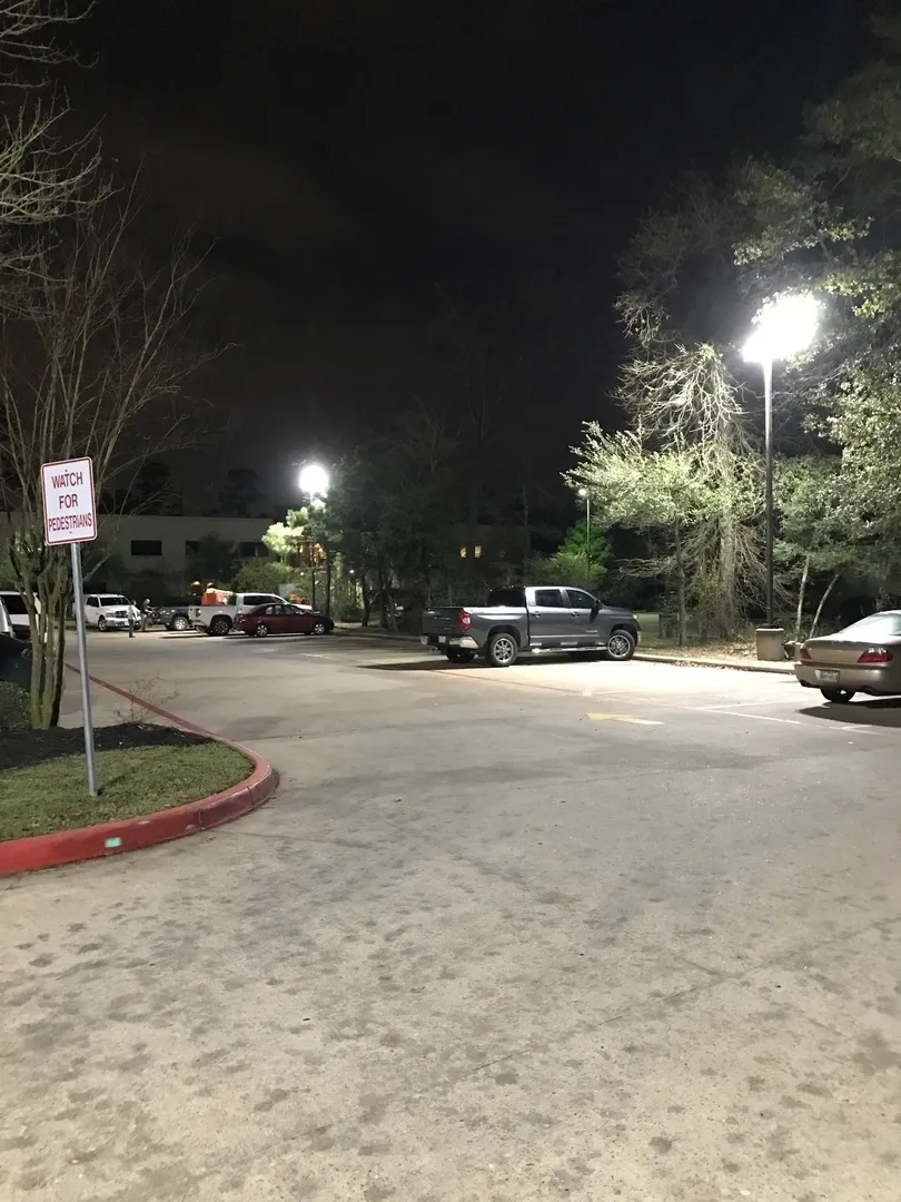 A parking lot with cars parked in it at night.