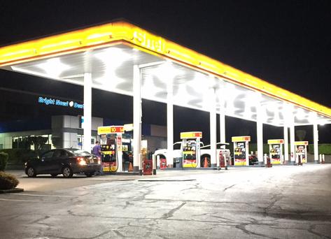 A gas station with cars parked at the pumps.