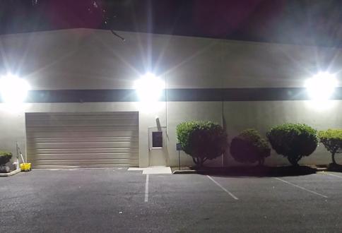 A parking lot with a garage door and street lights.