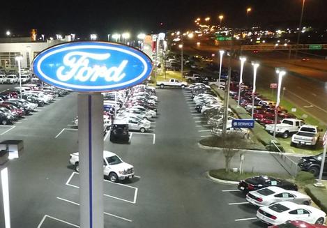 A view of a parking lot at night with cars parked in it.