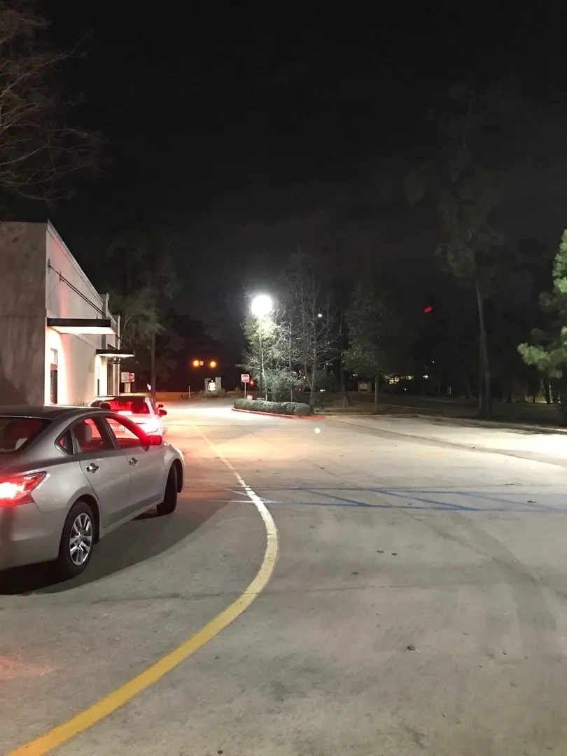 A car is parked on the side of the road at night.