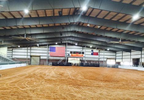 A large arena with an american flag on the wall.