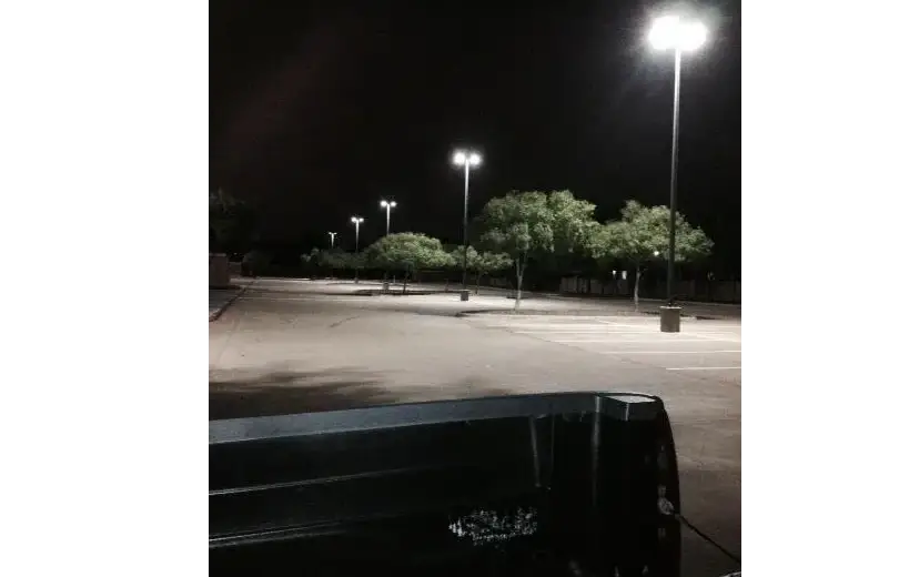 A truck parked in the middle of an empty parking lot.